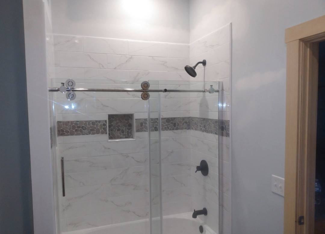 Marble tile shower with pebble accent