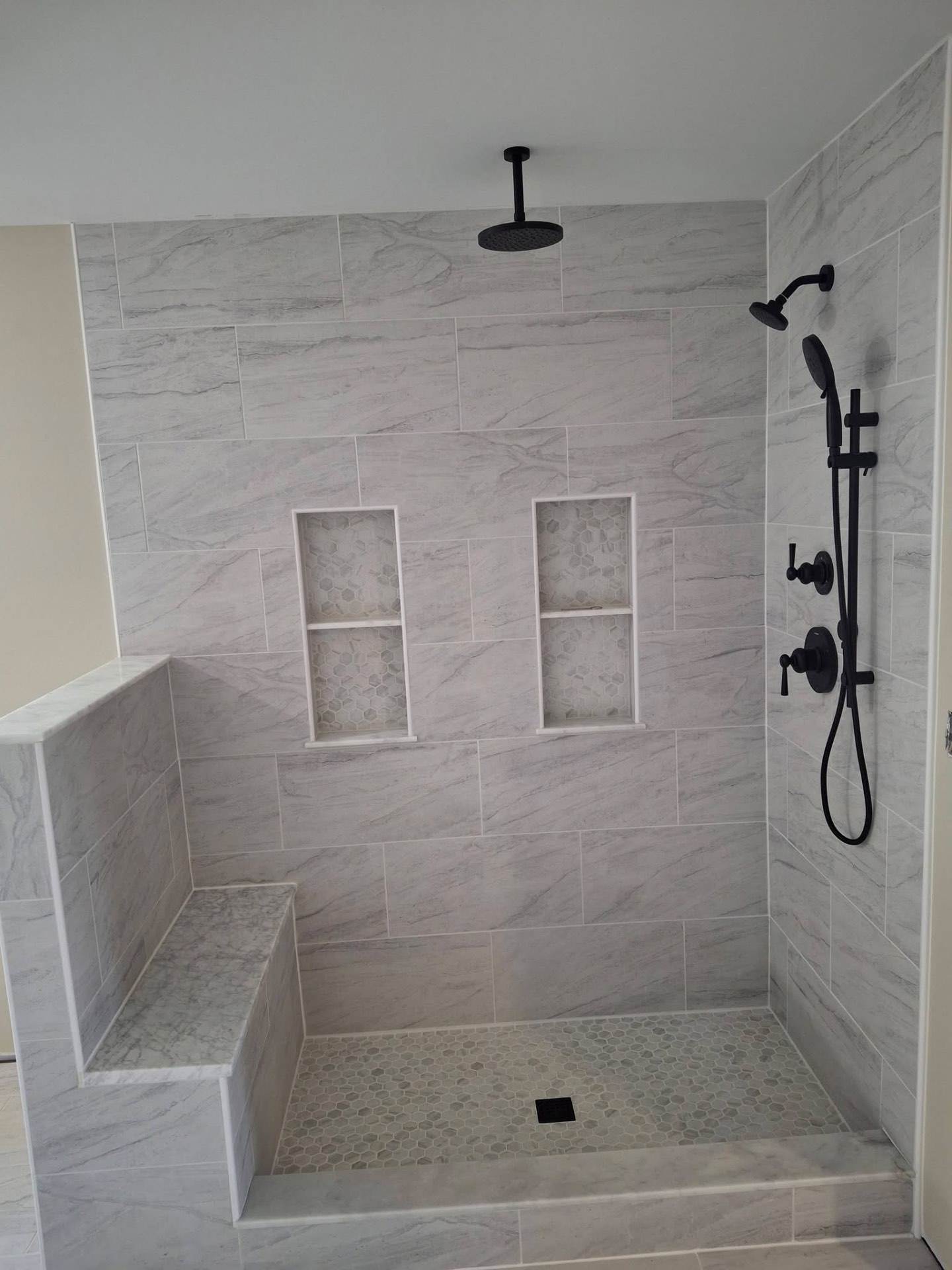 Tile shower with built-in bench and double niches